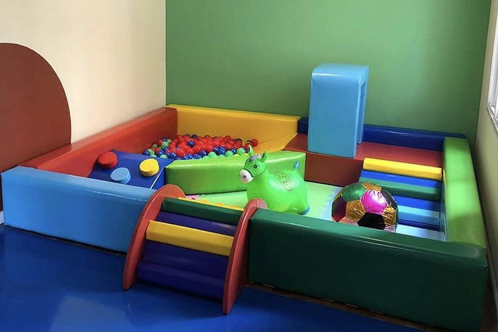 Área baby com blocos de espuma, muretas baixas, rampa e piscina de bolinhas para a primeira infância